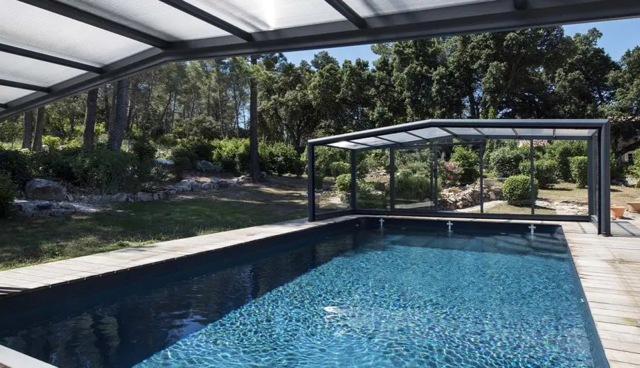 Piscine avec terrasse en bois et abri de piscine ouvert sur les deux côtés