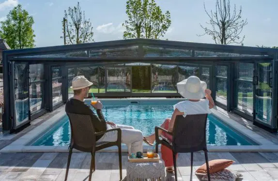 Couple devant un abri de piscine avec du soleil