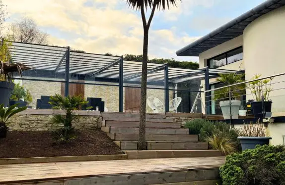 Abri de piscine adossé Sokool avec palmier et ciel bleu