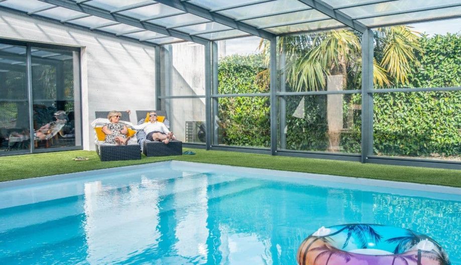 Couple au bord du bassin d'un piscine avec un abri