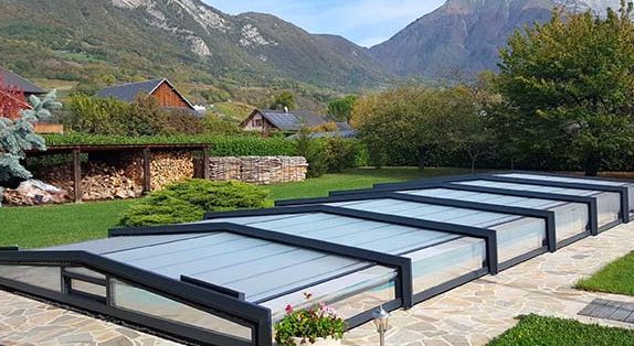 Piscine couverte par un abri dans un jardin au pied des montagnes