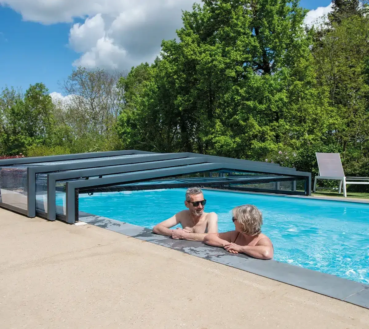 Couple se baignant en se regardant dans une piscine avec un abri replié