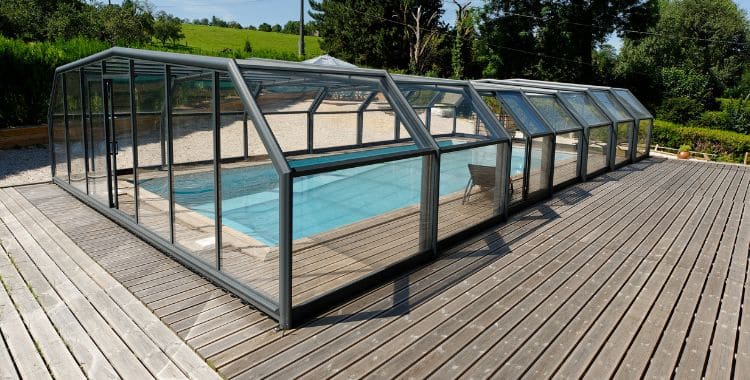 Terrasse en bois avec une piscine recouverte par un abri