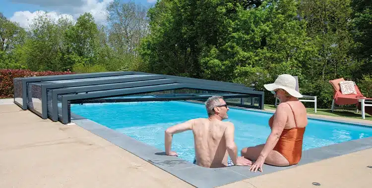 Couple se baignant dans une piscine avec un abri de piscine semi-ouvert
