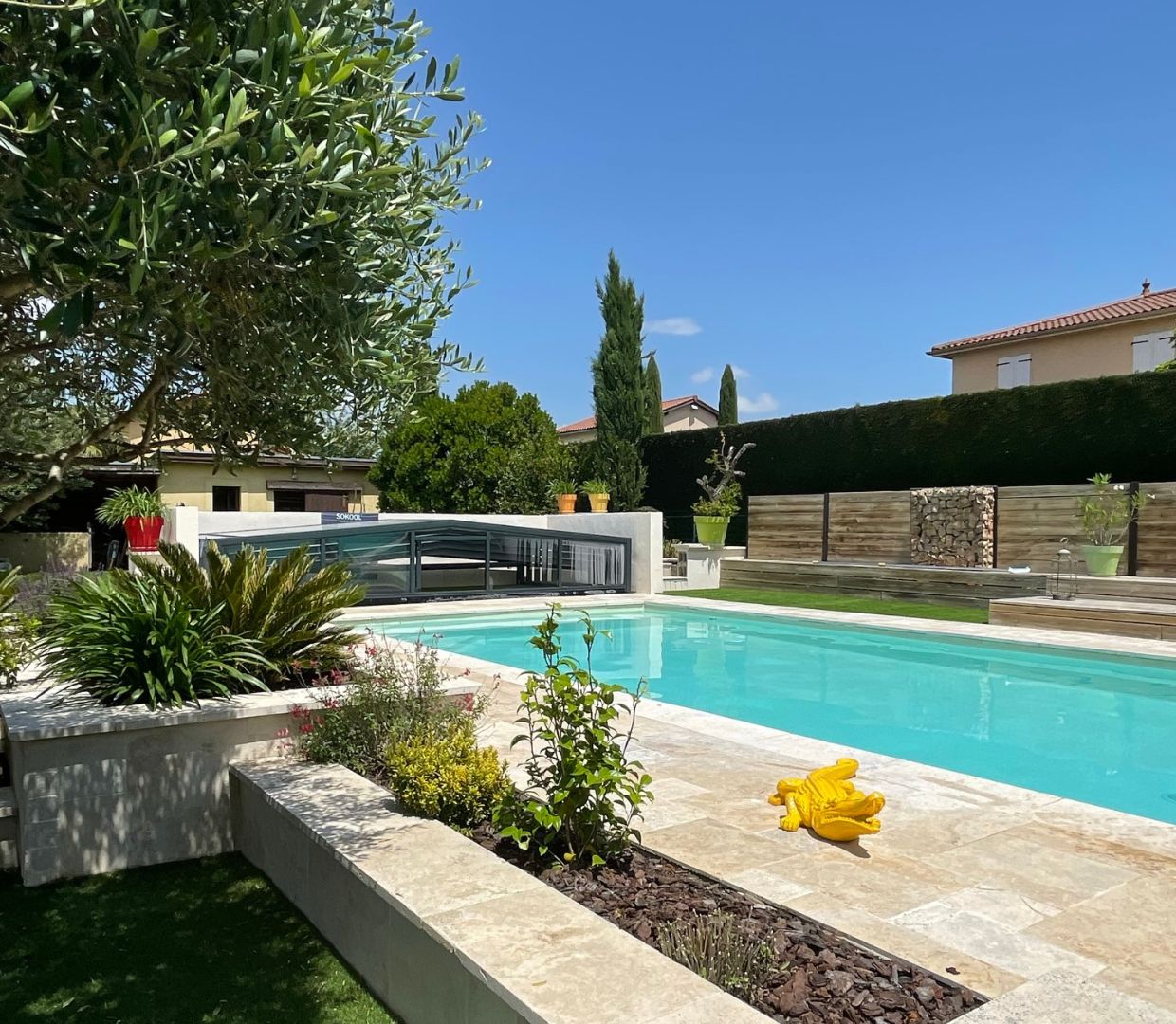 Piscine ouverte avec ciel bleu et abri de piscine replié